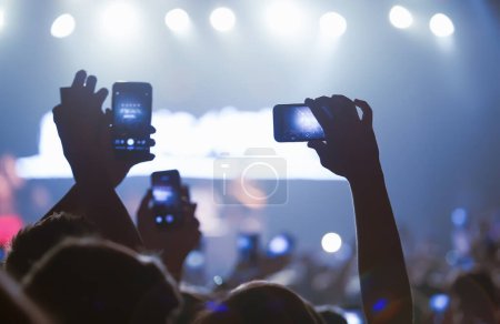 Téléchargez les photos : Foule de concerts avec téléphones portables. Mer des mains filmer le spectacle avec des smartphones - en image libre de droit