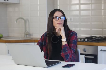 Photo for Pensive young woman in glasses thinking about problem solution. Yong adult female looking away in thought about work - Royalty Free Image