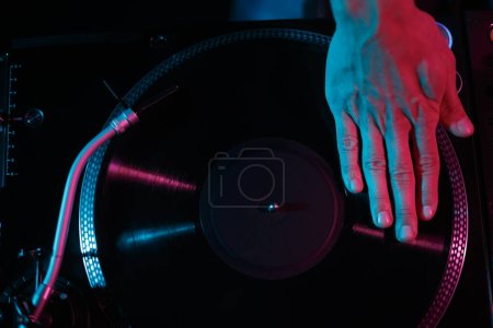 Photo for Hip hop dj scratching vinyl record on party in night club. Overhead stock photo of turntable on stage. Disc jockey mixing music on concert. - Royalty Free Image