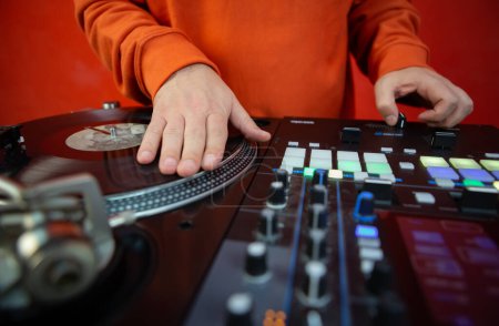 Foto de Hip hop dj scratching vinyl record on turntable player. Close up photo of disc jockey playing music on party. Disk jokey scratches disc with music on deck - Imagen libre de derechos