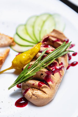 Foto de Foie gras pasta con hierba de romero. Deliciosa mousse de hígado de pato servido con salsa de arándanos y hierbas en el restaurante francés - Imagen libre de derechos