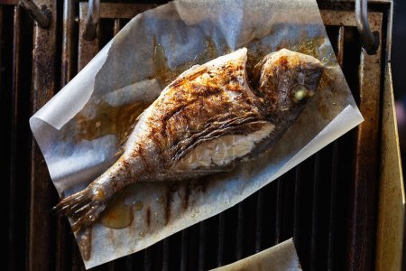Téléchargez les photos : Délicieux dorado poisson cuisson sur le gril. Poisson mahi-mahi entier cuit pour le dîner au restaurant asiatique de fruits de mer - en image libre de droit