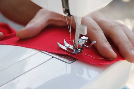Photo for Tailor sews clothes on electrc sewing machine in close up, focus on needle. - Royalty Free Image