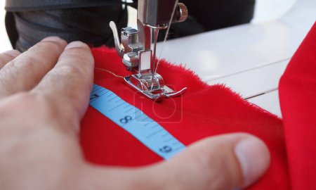 Foto de Taylor paño de costura con máquina de coser eléctrica profesional. Enfoque de cerca en la aguja en textil - Imagen libre de derechos