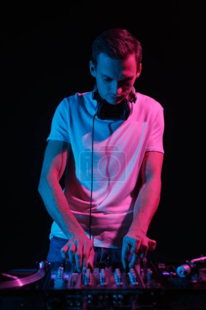 Foto de Cool club DJ mezclando discos en la fiesta. Profesional disc jockey jugando conjunto en el escenario en el club nocturno - Imagen libre de derechos