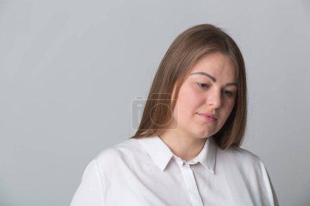 Foto de Retrato de estudio de una mujer infeliz con sobrepeso. Joven adulto ucraniano mujer mirando hacia abajo en la frustración - Imagen libre de derechos