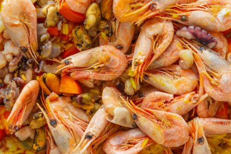 Photo for Traditional Spanish paella with seafood cooked for lunch. Delicious Mediterranean risotto with shrimps, octopus, rice and mussels prepared for dinner - Royalty Free Image