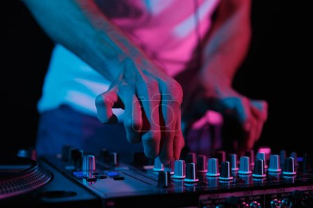 Foto de DJ mezclando música en la fiesta. Club disc jockey ajuste de volumen en mezclador de sonido en primer plano, se centran en las manos - Imagen libre de derechos