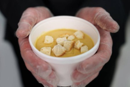 Foto de Cocinar tiene un tazón blanco de sopa de crema con croutons y champiñones - Imagen libre de derechos