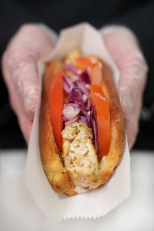Foto de Cocinar preparado sándwich de hot dog picante con carne blanca marinada, verduras frescas y salsa asiática picante - Imagen libre de derechos