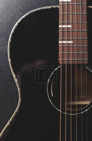 Photo for Beautiful black acoustic guitar in flat lay. Professional string instrument in close up - Royalty Free Image
