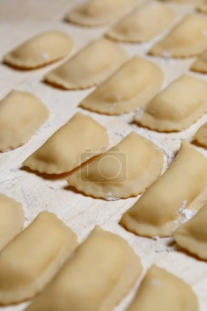 Photo for Traditional Ukrainian varenyki stuffed with potato being cooked in kitchen. Meat duplings cooking process - Royalty Free Image
