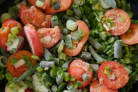 Foto de Verduras frescas congeladas que se cocinan en la sartén caliente en casa. Ingredientes saludables y naturales para una dieta baja en calorías - Imagen libre de derechos