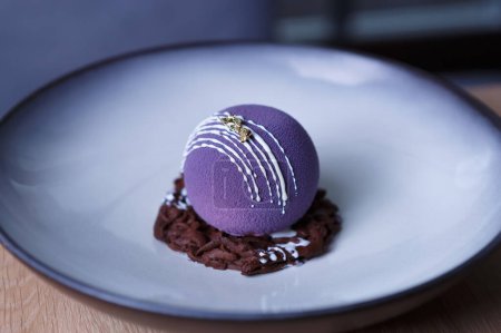Téléchargez les photos : Dessert décoratif violet servi pour le déjeuner au restaurant italien. Gâteau rond exotique sur une assiette - en image libre de droit