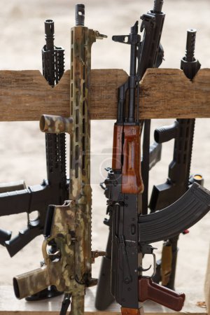 Photo for Modern American 5.56mm assault rifle and Kalashnikov 5.45mm on a weapon stand at outdoor shooting range - Royalty Free Image