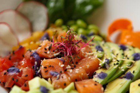 Téléchargez les photos : Délicieux poke bowl avec filet de saumon et légumes frais. Nourriture pescatarienne exotique préparée pour le déjeuner dans un café - en image libre de droit