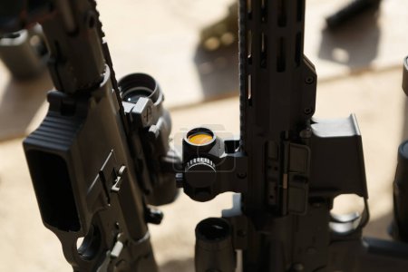 Foto de Fusiles de asalto estadounidenses modernos en un puesto de armas en el campo de tiro. Pistolas de carabina negra en primer plano - Imagen libre de derechos
