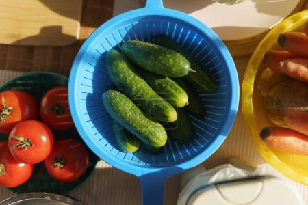 Photo for Fresh green cucumbers prepared for cooking salad. Vegetarian ingredients for healthy eating - Royalty Free Image