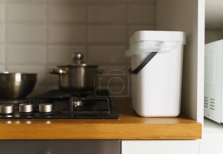 Téléchargez les photos : Poubelle à compost sur un comptoir de cuisine. Conteneur Bokashi pour le recyclage des déchets alimentaires organiques. Poubelle de compostage spécialisée pour restes compostables - en image libre de droit