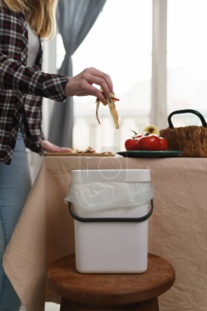 Photo for Female person recycling food leftovers in a compost bin. Woman cooking at home and throwing compostable organic waste in a bokashi container - Royalty Free Image