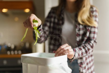 Téléchargez les photos : Femme mettre les déchets alimentaires organiques dans un récipient de compost. Femme recyclant les restes compostables dans une poubelle bokashi à la maison - en image libre de droit
