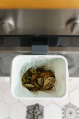 Téléchargez les photos : Déchets alimentaires organiques fermentant avec du son bokashi dans un bac à compost. Conteneur spécialisé pour restes d'aliments compostables dans une cuisine domestique - en image libre de droit