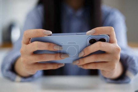 Téléchargez les photos : Gamer jouer à des jeux mobiles sur smartphone. Jeune fille joue jeu vidéo en ligne avec gadget moderne - en image libre de droit