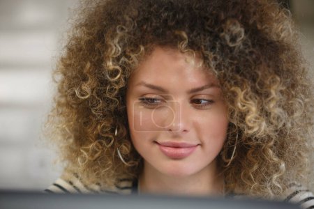 Téléchargez les photos : Curieuse femme blanche lisant du texte sur l'écran de l'ordinateur portable. Belle ukrainienne travaillant sur ordinateur à la maison - en image libre de droit
