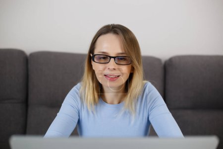 Photo for White woman working on notebook computer at home. Portrait of adult female person reading text on laptop screen - Royalty Free Image