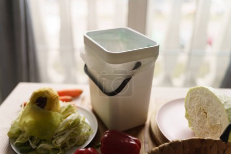 Téléchargez les photos : Poubelle à compost sur une table de cuisine. Recycler les déchets alimentaires organiques dans un récipient bokashi avec ferment. Style de vie durable et concept zéro déchet - en image libre de droit