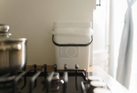 Téléchargez les photos : Bac à compost domestique sur un comptoir de cuisine. Conteneur Bokashi pour déchets alimentaires organiques et restes. Concept de mode de vie durable - en image libre de droit