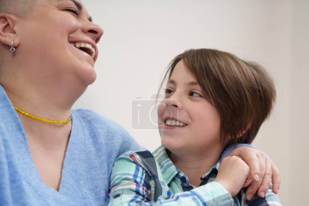 Photo for Happy Ukrainian family portrait. Short haired woman and little boy laughing in a cafe. Cheerful mother and elementary age son having fun together - Royalty Free Image