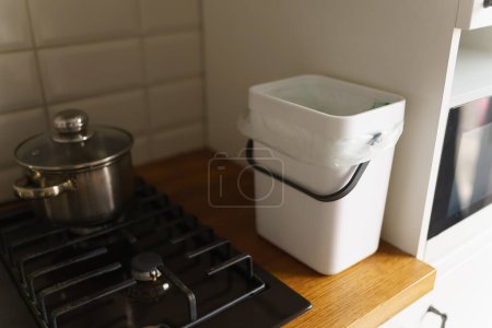 Téléchargez les photos : Bac à compost domestique sur un comptoir de cuisine. Bokashi récipient pour restes d'aliments biologiques. Style de vie durable et concept zéro déchet. - en image libre de droit