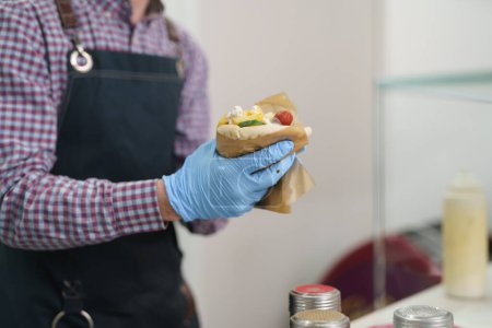 Foto de El cocinero preparando un sándwich de giroscopios para llevar. Chef cocina tradicional griega envoltura con pan de pita y carne souvlaki - Imagen libre de derechos