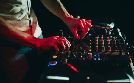 Téléchargez les photos : Disque jockey professionnel jouant ensemble de musique avec mélangeur sonore et platines vinyle. Techno DJ en boîte de nuit - en image libre de droit