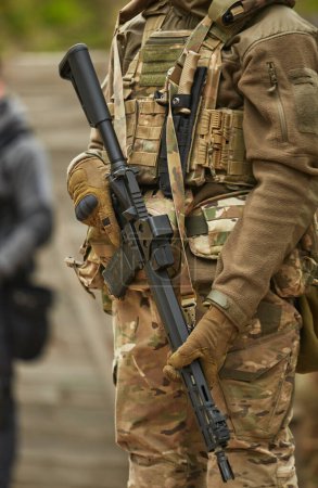 Foto de Soldado ucraniano armado con un moderno rifle de asalto estadounidense equipado con amplificador de alcance de entrenamiento en el campo de tiro. Fuerzas armadas de Ucrania reclutan practicando al aire libre - Imagen libre de derechos