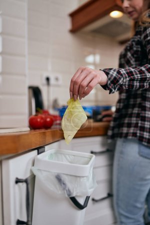 Photo for The cook throwing food peels in a compost bin for fermentation. Responsible female person recycling organic leftovers in a bokashi container at home. Sustainable lifestyle concept - Royalty Free Image