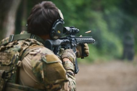 Photo for Ukrainian soldier shooting on sight with a modern American assault rifle equipped with optical scope. Armed forces of Ukraine training for the counter offensive operation - Royalty Free Image