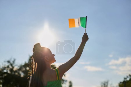 Niña irlandesa ondeando con la bandera de Irlanda en el festival de San Patricio