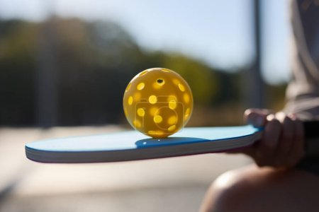 Pickle-Ball-Spieler jongliert mit Ball auf Schläger
