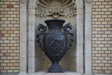 Photo for Bronze vase with a Greek ornament in a alcove in a wall of Varkert Bazar (Hungarian: Vrkert Bazaar or Vrbazr). Budapest, Hungary - 7 May, 2019 - Royalty Free Image