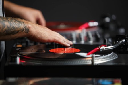 Photo for Club DJ scratching a record on a hip hop party. Professional disc jockey mixing music set - Royalty Free Image