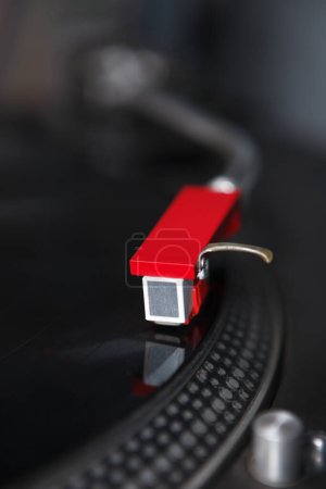 Cartucho de aguja roja en un tonearm de un tocadiscos. Dispositivo reproductor de discos de vinilo