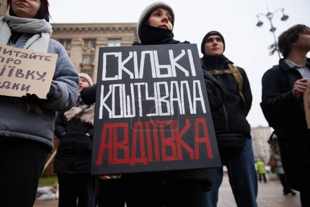Téléchargez les photos : Des militants ukrainiens tiennent une affiche "Combien Avdiivka a coûté ?" sur un rassemblement public pour l'augmentation du budget militaire. Kiev - 17 février 2024 - en image libre de droit