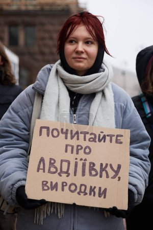 Téléchargez les photos : Militant ukrainien montre une bannière "Lisez à propos d'Avdiivka, vous les monstres" sur une manifestation publique pour l'augmentation du budget militaire. Kiev - 17 février 2024 - en image libre de droit