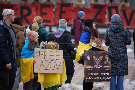 Foto de Niños ucranianos con banderas nacionales muestran una pancarta "Azov Libre" en una manifestación. Kiev - 11 de febrero de 2024 - Imagen libre de derechos