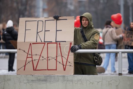 Foto de Hombre ucraniano sostiene una pancarta "Azov Libre" en una manifestación pública en la ciudad. Kiev - 11 de febrero de 2024 - Imagen libre de derechos