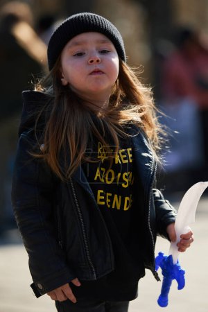 Photo for Little Ukrainian girl wearing a shirt "Free Azovstal Defenders" on a demonstration. Kyiv - 10 March,2024 - Royalty Free Image