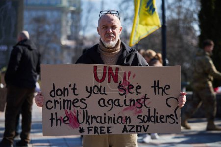 Foto de Activista posando con una pancarta "ONU, ¿no ves los crímenes contra los soldados ucranianos? Free Azov "en una manifestación pública. Kiev - 10 de marzo de 2024 - Imagen libre de derechos