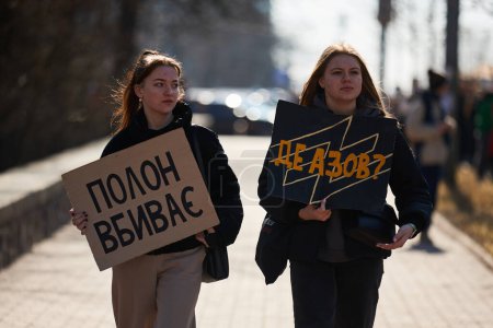 Foto de Jóvenes ucranianas caminan con pancartas "El cautiverio mata" y "¿Dónde está Azov?" en una manifestación por la liberación de los defensores capturados de Ucrania. Kiev - 10 de marzo de 2024 - Imagen libre de derechos